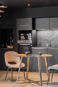 a kitchen with a table and two chairs and a sink at 7eme loft in Saint-Victor-de-Cessieu