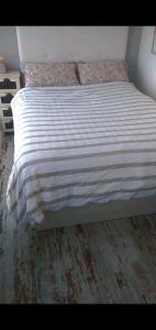 a bed with a striped comforter in a bedroom at Atico España in Las Rozas de Madrid