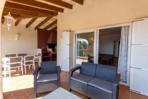 uma sala de estar com duas cadeiras e uma mesa em Villa Primrosa - beautiful sea views em Son Bou
