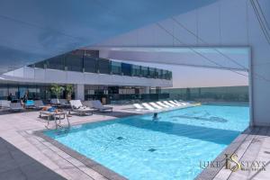 een groot zwembad met stoelen en een gebouw bij Luxury Oasis Hideaway in Dubai
