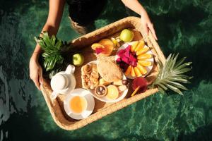 a person holding a tray of food on a boat at Mahitala Villa Bandung Heated Pool in Bandung