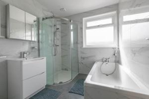 a bathroom with a shower and a tub and a sink at 3 bed family hse, Games Room, Parking, Garden in Kent