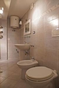 łazienka z toaletą i umywalką w obiekcie bonfire house w mieście San Giacomo in Paludo