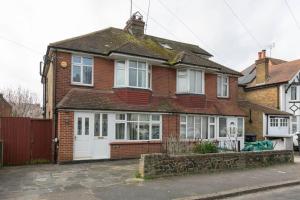a red brick house with a white garage at 3 bed family hse, Games Room, Parking, Garden in Kent