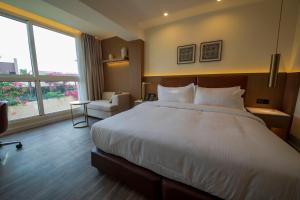 a hotel room with a large bed and a window at Luxotel Aqaba Beach Resort & Spa in Aqaba