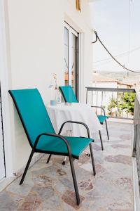 a table and four chairs on a balcony at Mavromati Rooms 2 in Kiveri