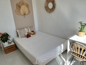 een kleine slaapkamer met een bed en een stoel bij Appartement à 10 min de la plage - T4, 9ème in Marseille