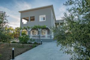 Villa Erato Family في Mouzákion: منزل أبيض كبير مع ممر