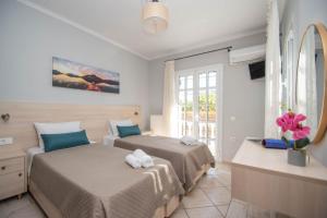 Villa Erato Family في Mouzákion: غرفة نوم بها سريرين ونافذة
