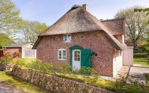 an old brick house with a thatched roof at Hartelk in Nebel