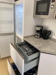 a kitchen with a refrigerator and a stove top oven at City & Beach Top-Floor Apartment in Fuengirola