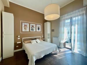 ein Schlafzimmer mit einem weißen Bett und einem großen Fenster in der Unterkunft Casa Gramsci Anzio Centro in Anzio