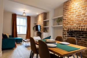 a living room with a table and a brick fireplace at Contractor 3Bed Home in Central Cardiff Ideal for Long Stays Free On Street Parking in Cardiff