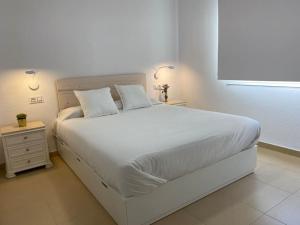a bedroom with a large white bed with two pillows at City & Beach Top-Floor Apartment in Fuengirola