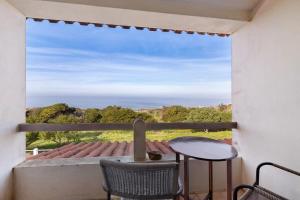 a view from a balcony with a table and chairs at Alto da Praia Villa in Colares