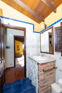 ein Bad mit einem Waschbecken und einem Spiegel in der Unterkunft La Casona Del Cura II in Pravia