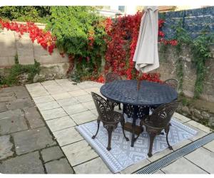a table with chairs and an umbrella on a patio at Contractor 3Bed Home in Central Cardiff Ideal for Long Stays Free On Street Parking in Cardiff