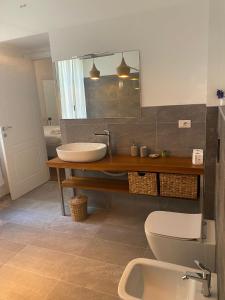 ein Badezimmer mit einem Waschbecken, einem WC und einem Spiegel in der Unterkunft Palazzo Venezian 5 in Triest