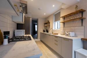a kitchen with a stove top oven next to a sink at Contractor 3Bed Home in Central Cardiff Ideal for Long Stays Free On Street Parking in Cardiff