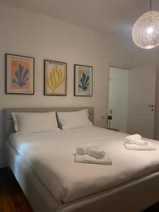 a bedroom with a white bed with towels on it at Palazzo Venezian 5 in Trieste