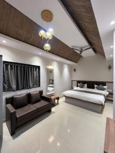 a large bedroom with a bed and a couch at Woodrose villa mahabaleshwar in Satara