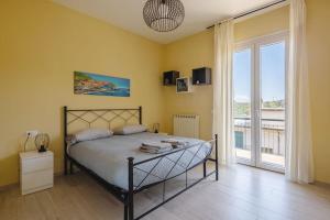 a bedroom with a bed and a large window at Le Grazie - Portovenere / Appartamento spazioso e luminoso con balconi vista mare aria condizionata e parcheggio (attenzione alle misure) in Le Grazie