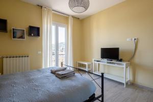 a bedroom with a bed and a television and a window at Le Grazie - Portovenere / Appartamento spazioso e luminoso con balconi vista mare aria condizionata e parcheggio (attenzione alle misure) in Le Grazie