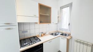 a small kitchen with a sink and a stove at Le Due Farfalle by Ca-Sa Check in Chioggia