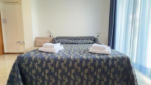 a bedroom with a bed with two pillows on it at Le Due Farfalle by Ca-Sa Check in Chioggia