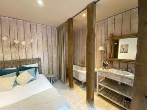 um quarto com uma cama, uma banheira e um lavatório em La Villa du Grand Large em Biscarrosse