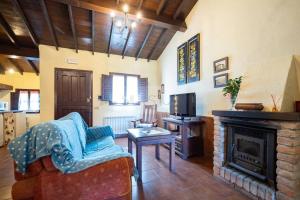 sala de estar con sofá y chimenea en La Casona Del Cura I en Pravia