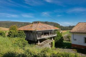 un edificio con techo sobre un campo en La Casona Del Cura I en Pravia