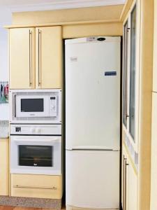 een keuken met een witte koelkast en een magnetron bij Encantador piso en el Grao de Valencia in Valencia