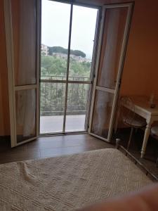 sypialnia z dużym oknem z biurkiem i stołem w obiekcie Casa Chiara w mieście Scilla