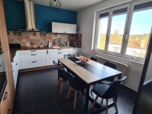 una cocina con mesa de madera y sillas. en Maison rénovée 4 chambres., en Angulema