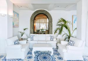 a living room with white furniture and a mirror at Miramare E Castello in Ischia