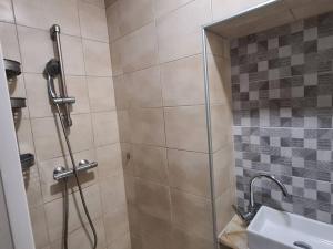 eine Dusche mit Glastür neben einem Waschbecken in der Unterkunft Maison rénovée 4 chambres. in Angoulême