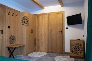 Pokój z drewnianymi drzwiami i telewizorem w obiekcie Willa Zagroniówka w Istebnej