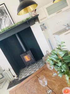 een woonkamer met een open haard en een tafel met wijnglazen bij Maison de l'enfant gites 