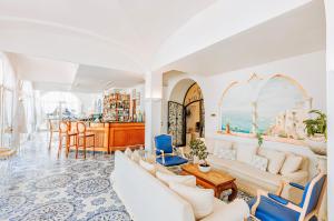 a living room with white furniture and a bar at Miramare E Castello in Ischia