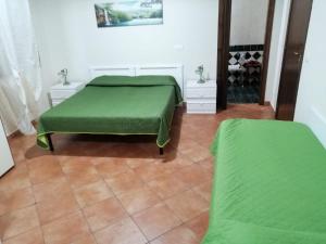 sypialnia z 2 łóżkami i zieloną pościelą w obiekcie Casa Chiara w mieście Scilla