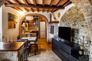 a kitchen and dining room with a stone wall at Casa nelle Mura in Caldana