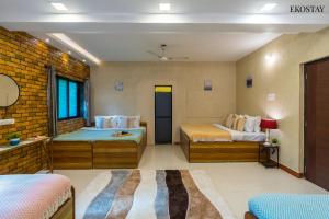 a bedroom with two beds and a brick wall at EKO STAY- PANORAMA VILLA in Alibaug