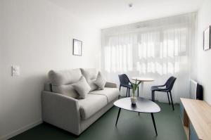 a living room with a couch and a table at Sweetly I-Art Gradignan - Bordeaux Sud in Gradignan +19 photos