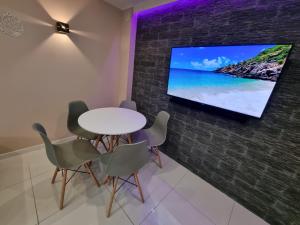 a dining room with a table and a tv on a wall at Apartament MASHOUSE Stegna in Stegna