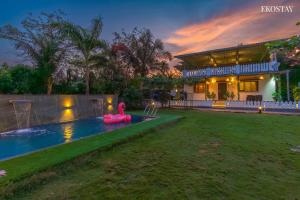 a house with a pool and a pink swan in the yard at EKO STAY- PANORAMA VILLA in Alibaug