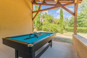 a pool table sitting inside of a house at Villa Vezac in Vézac