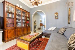 uma sala de estar com um sofá e uma mesa em A Lovely 3BR Maisonette in lovely town of Rabat by 360 Estates em Busugrilla