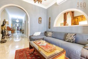 uma sala de estar com um sofá e uma mesa em A Lovely 3BR Maisonette in lovely town of Rabat by 360 Estates em Busugrilla