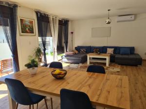 a living room with a wooden table and blue chairs at OLD TOWN ROAD in Karlovac